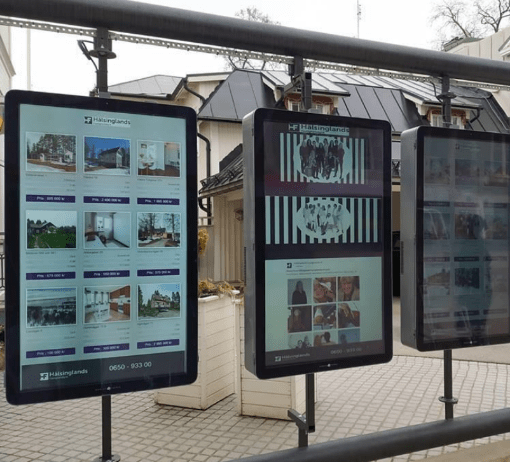 Digitala utomhusskärmar som visar objekt som en mäklare säljer.